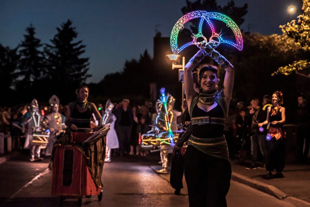 Une artiste avec un cerceau lumineux lors d’une déambulation de nuit, spectacle Ardensia