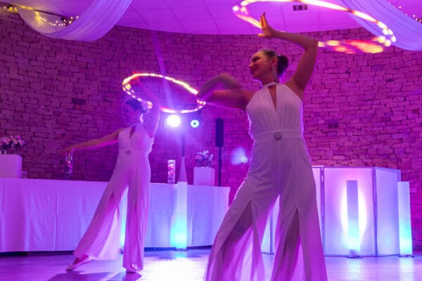 Deux artistes avec des cerceaux LED lumineux dans une salle de réception au Domaine de la Gillardière