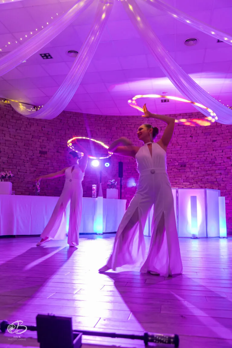 Deux artistes avec des cerceaux LED lumineux dans une salle de réception au Domaine de la Gillardière