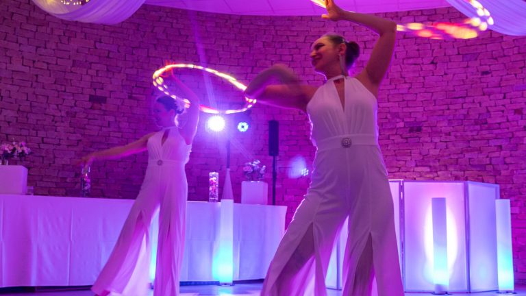 Deux artistes avec des cerceaux LED lumineux dans une salle de réception au Domaine de la Gillardière