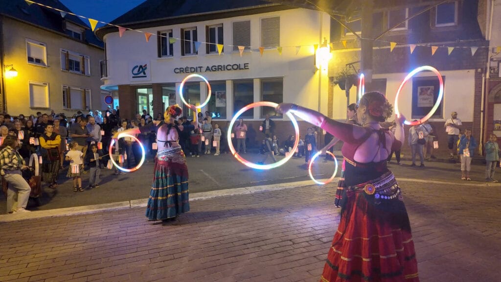 Artistes de Nomade avec des cerceaux lumineux en déambulation dans une rue